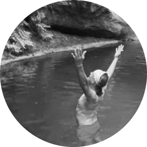 Dominic Idier, professeur de Yoga Primal, se tenant dans l'eau avec les bras levés vers le ciel, symbolisant la connexion avec la nature et l'énergie universelle.