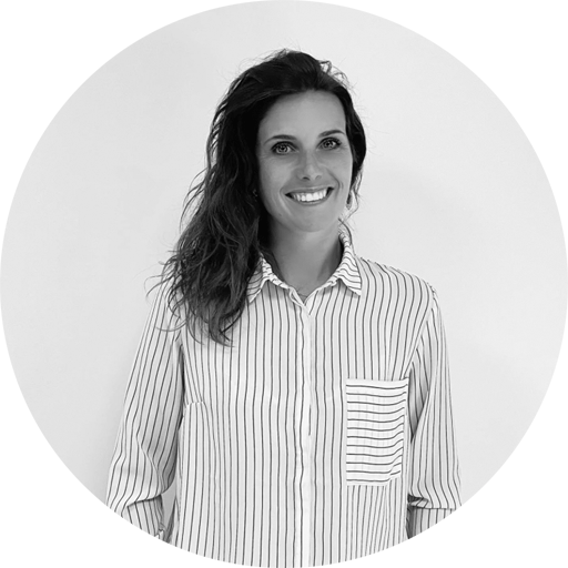 Portrait en noir et blanc de Sandra Gramoli, professeure de danse et Pilates, tenant un chapeau et souriante dans un cadre naturel