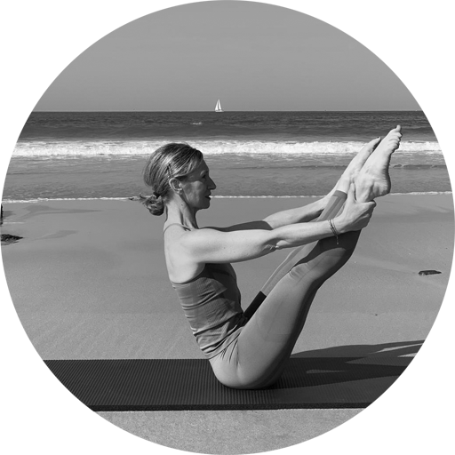 Portrait en noir et blanc de Véronique Bozier, professeure de Pilates, effectuant une posture de Pilates sur une plage avec l'océan en arrière-plan.